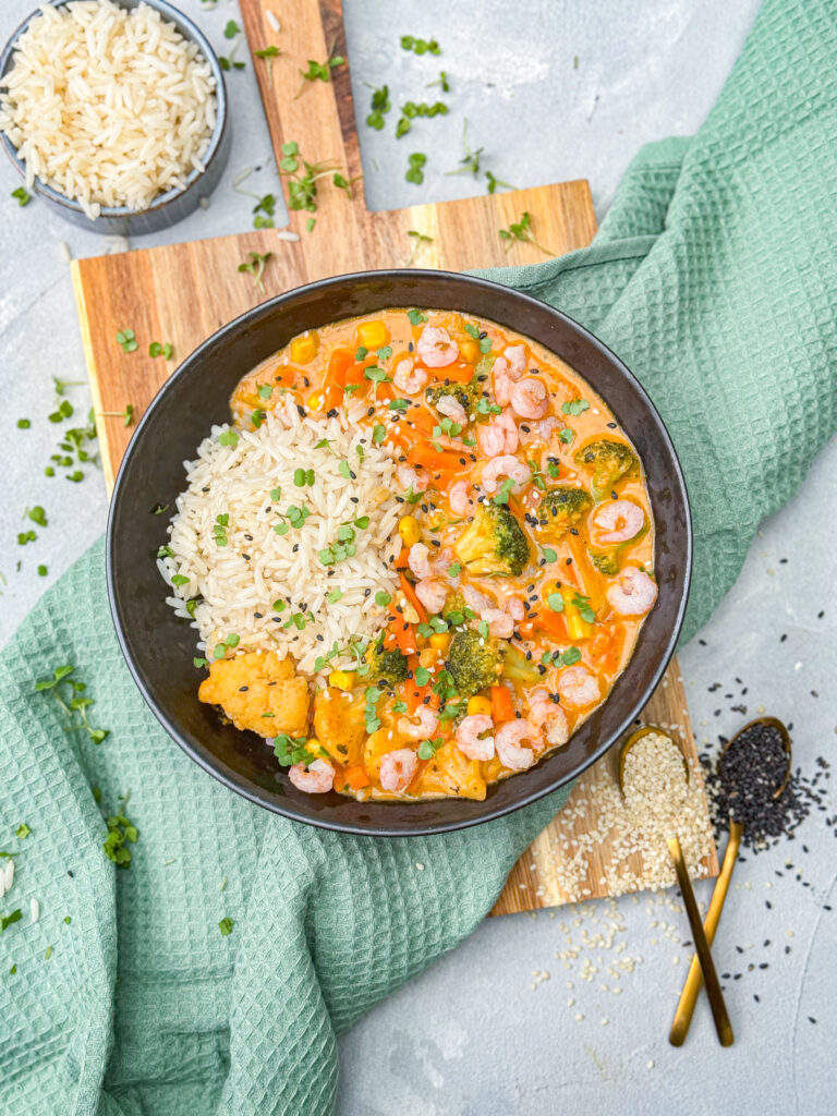 Gebratene Garnelen mit Gemüse in Curry und dazu Reis